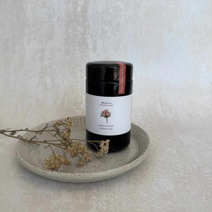 Whole plant facial exfoliant beside dried yarrow flowers on ceramic dish